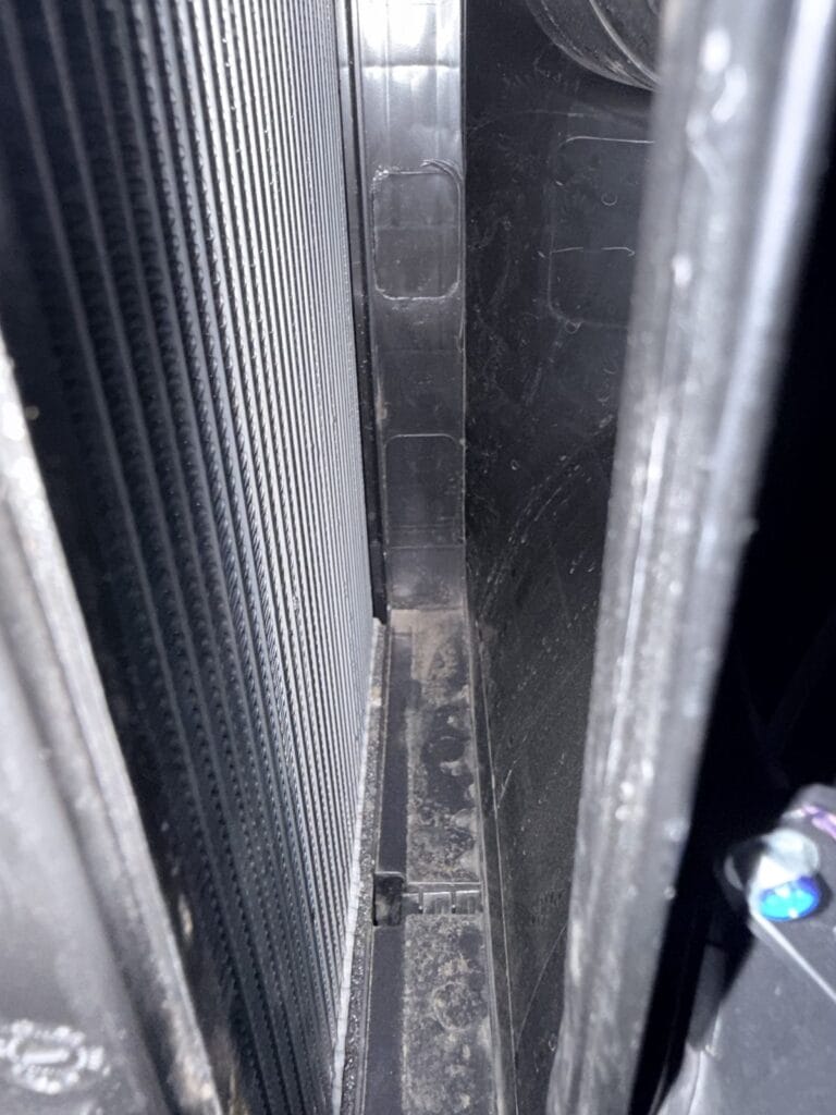 Dirty Tesla Model Y AC evaporator before cleaning, seen through the cabin filter opening