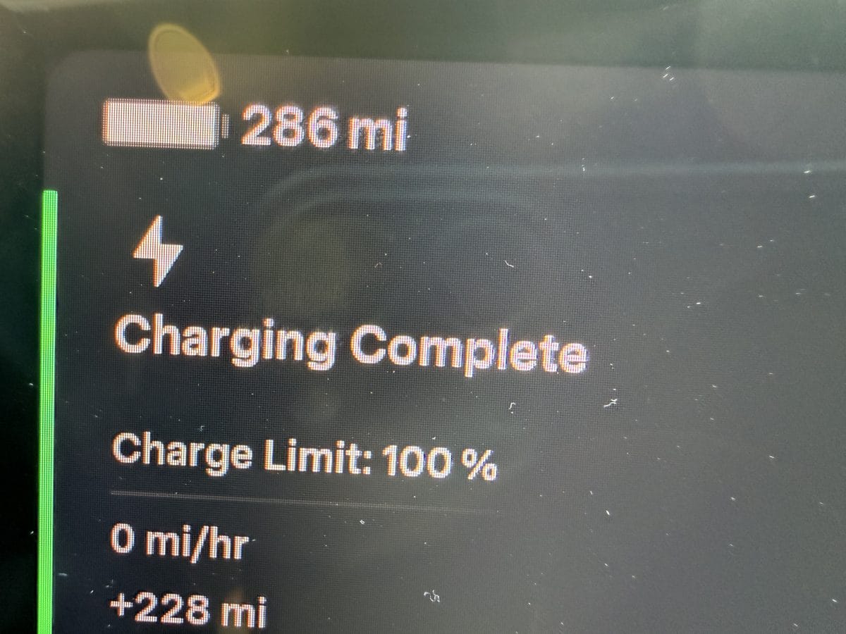 Tesla Model Y screen showing 286 miles of range at a 100% full charge