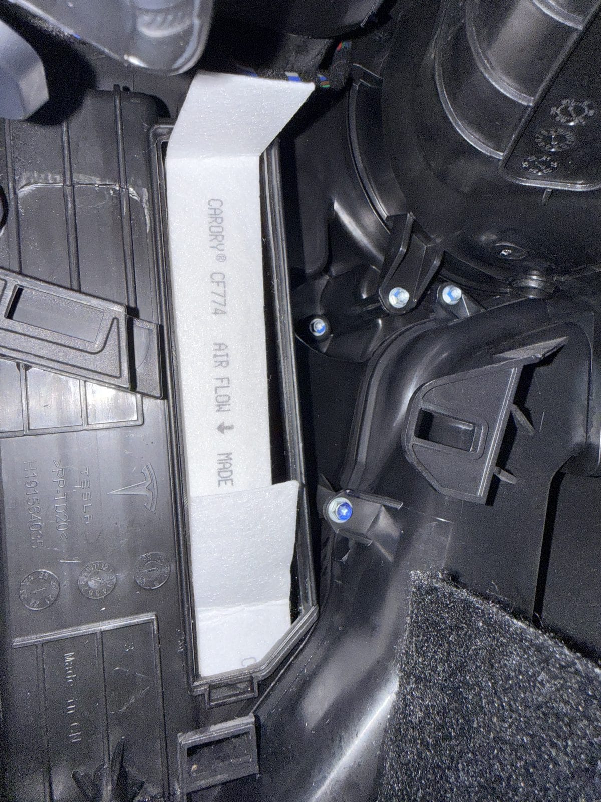New cabin air filter installed in a Model Y with the pull tab facing out and up