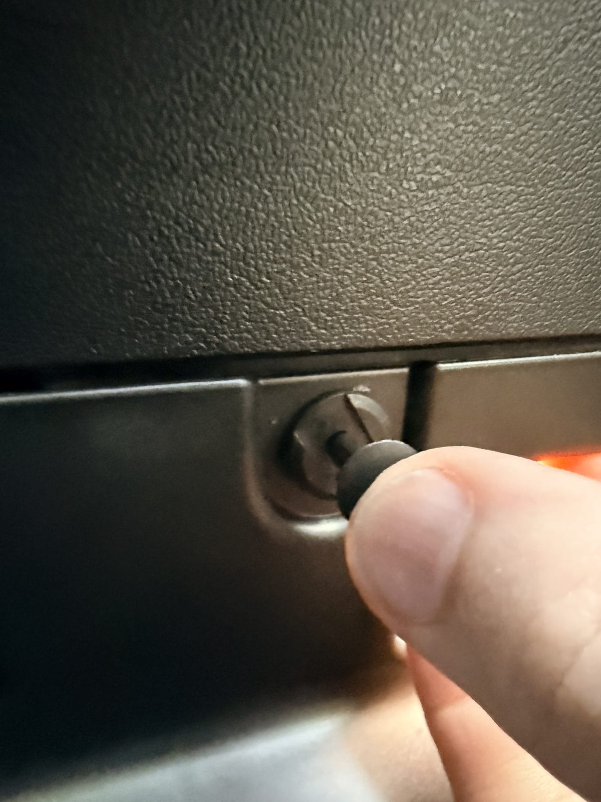 Reinstalling a push pin in the Model Y under-glovebox cover