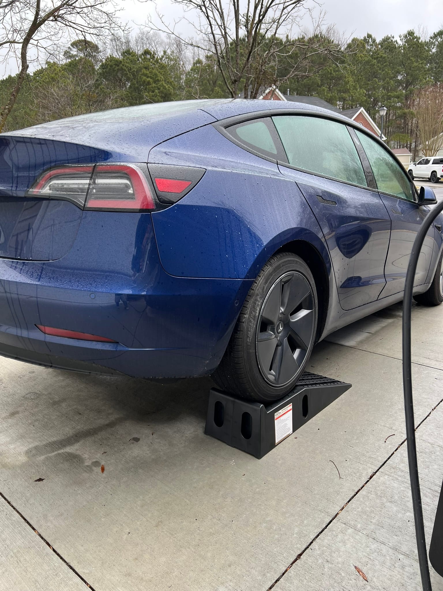 Tesla Model 3 rear wheel on car ramps for skid plate replacement