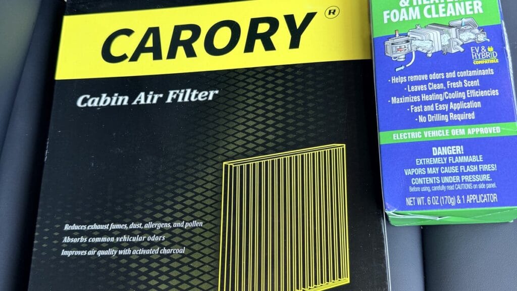 Tesla Model Y cabin air filter replacement supplies — CARORY filter kit and Kool-It evaporator foam cleaner on the passenger seat