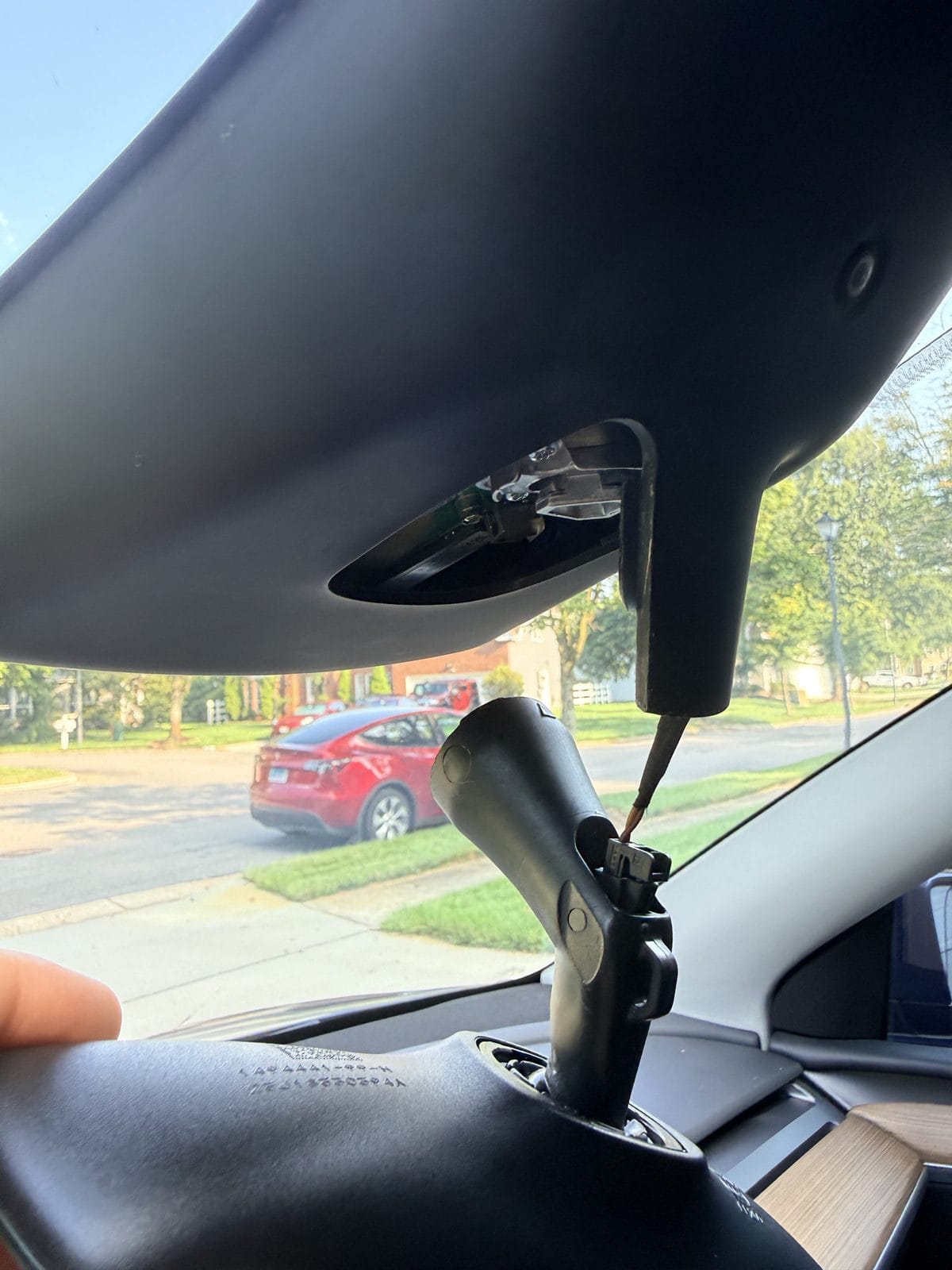 Removing the Tesla Model Y rearview mirror with a quarter-turn twist of the base