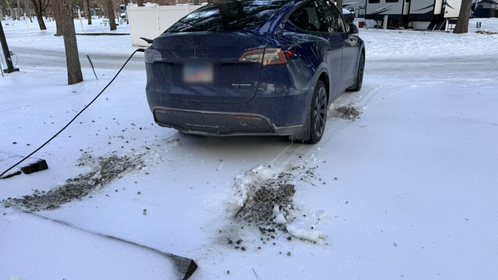 Tesla road trip packing list — Model Y charging at a snowy campground RV pedestal