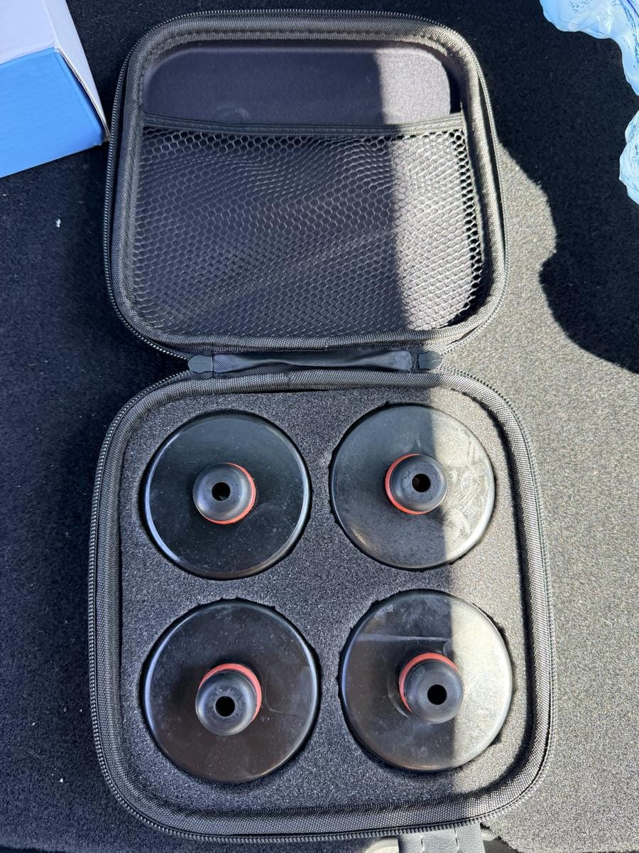 Set of four Tesla jack pads with locating pins in their storage case