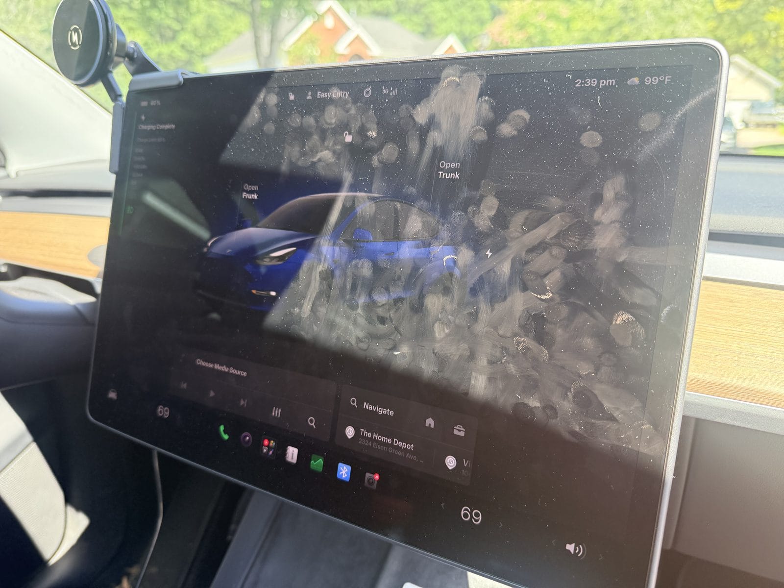 Fingerprints and glare on a bare Tesla center touchscreen, showing why a Tesla screen protector is usually the wrong fix